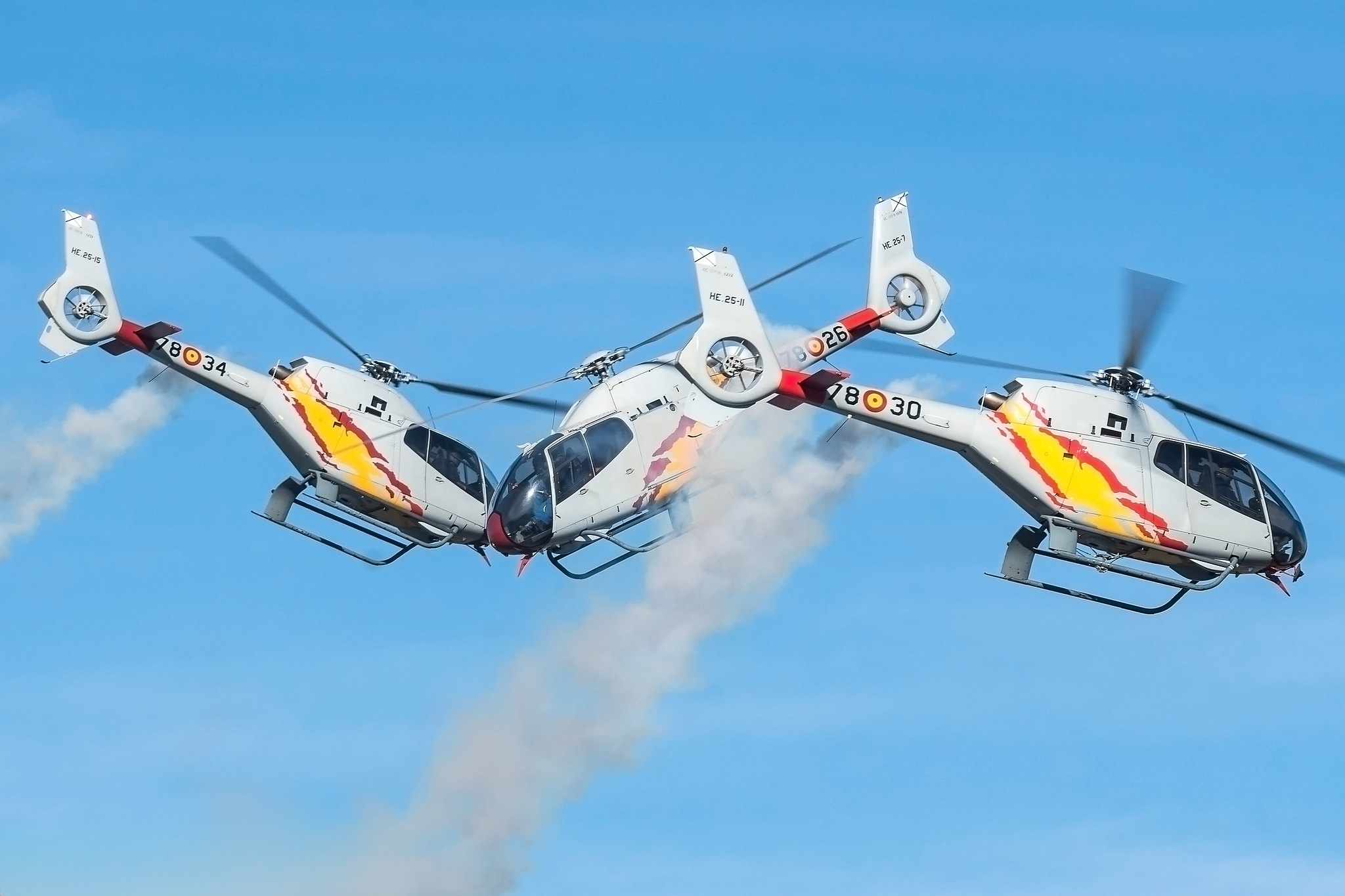 Formación de la Patrulla Aspa dibujando humo en el cielo